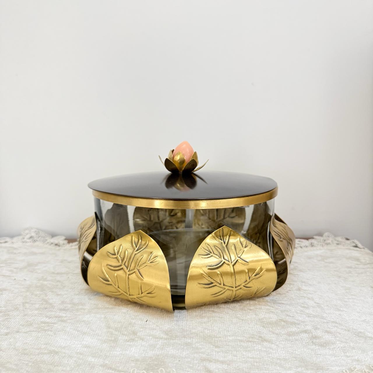 Decorative glass box with gold leaf design on a white surface