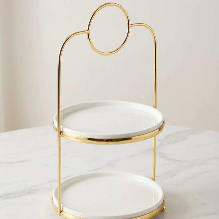 Two-tiered white dish with gold rim on a marble surface