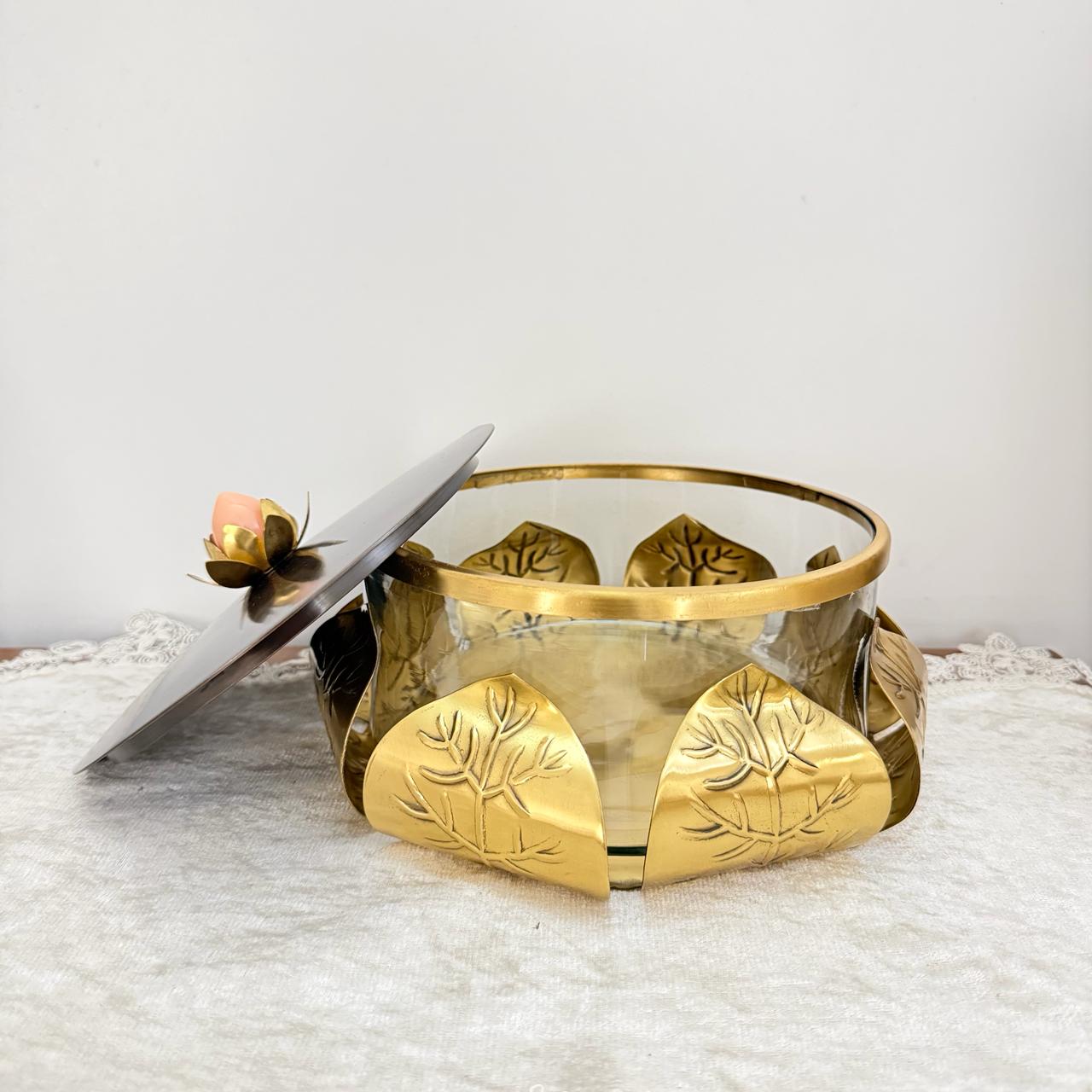 Gold decorative bowl with leaf designs on a textured surface