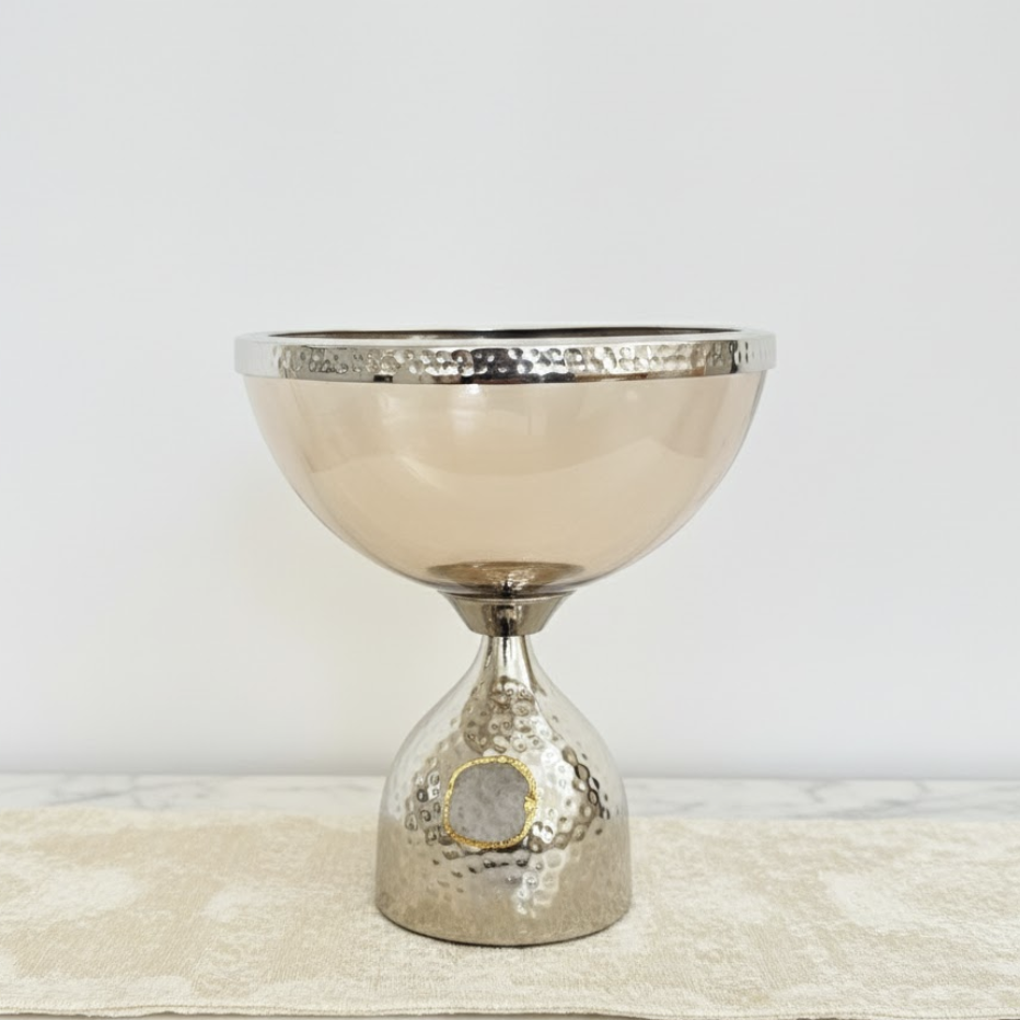 Decorative metallic bowl with textured design on a light background