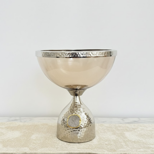 Decorative metallic bowl with textured design on a light background