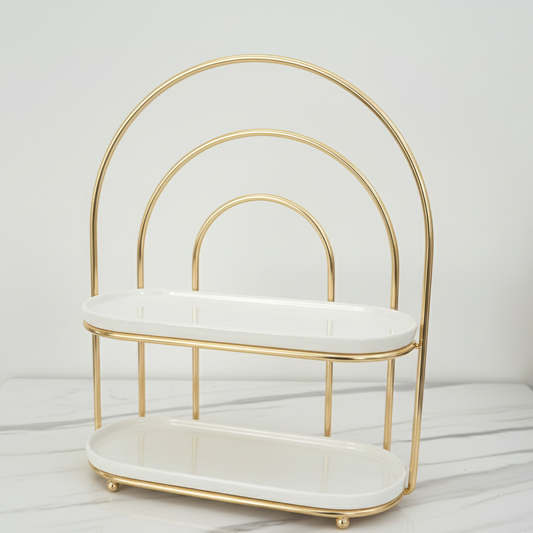 Gold and white decorative shelf on a light wooden surface with a neutral background