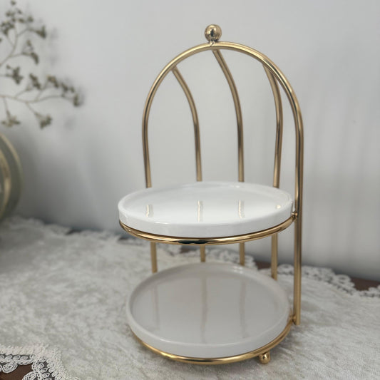 Small gold-framed chair with white cushion on a textured surface