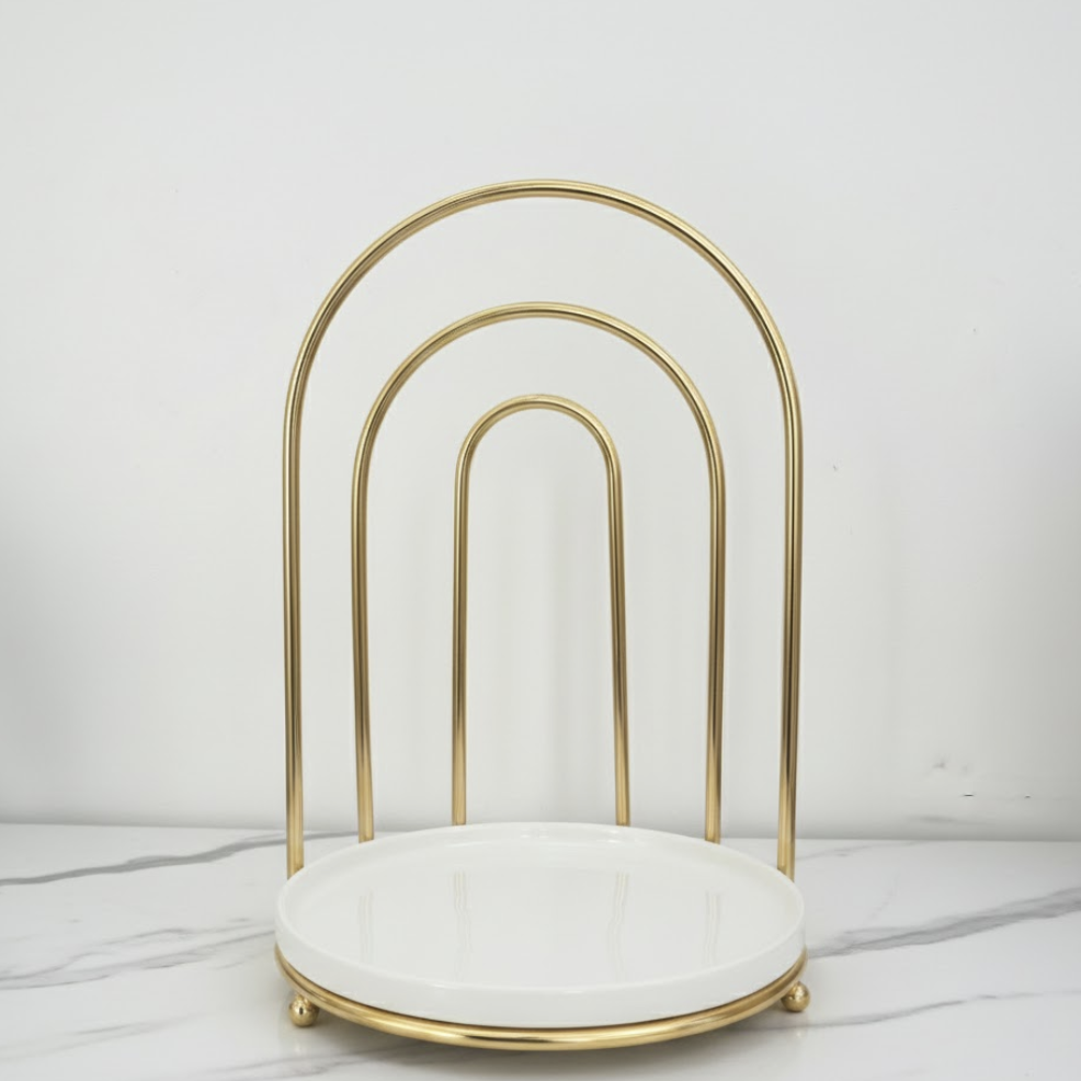 Gold arch-shaped stand with a white cushion on a light gray background