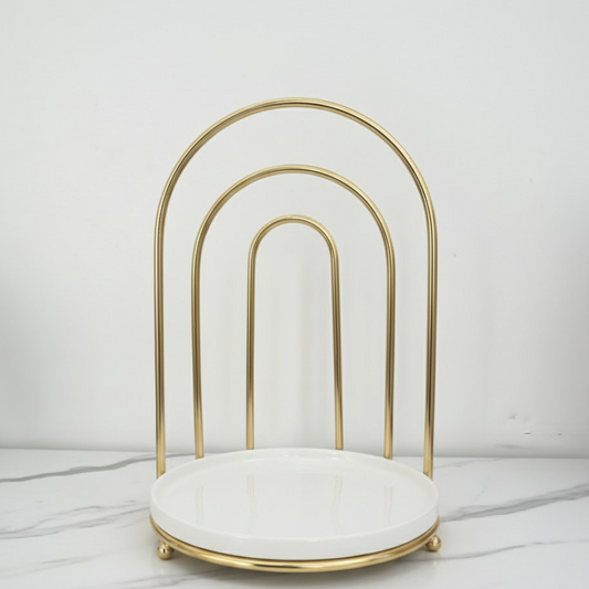 Gold arch-shaped stand with a white cushion on a light gray background
