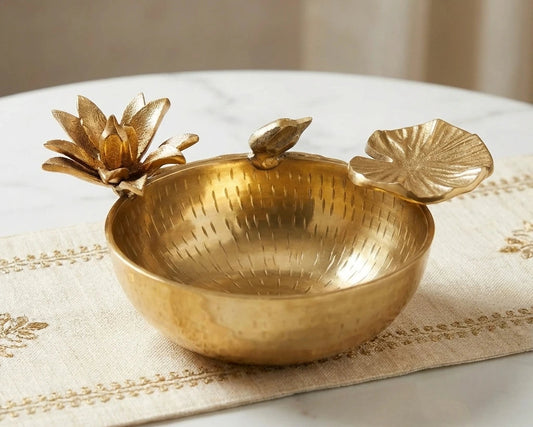 Gold decorative bowl with leaf designs on a marble surface