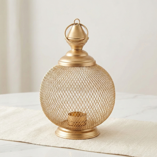 Gold mesh lantern on a white surface with a neutral background