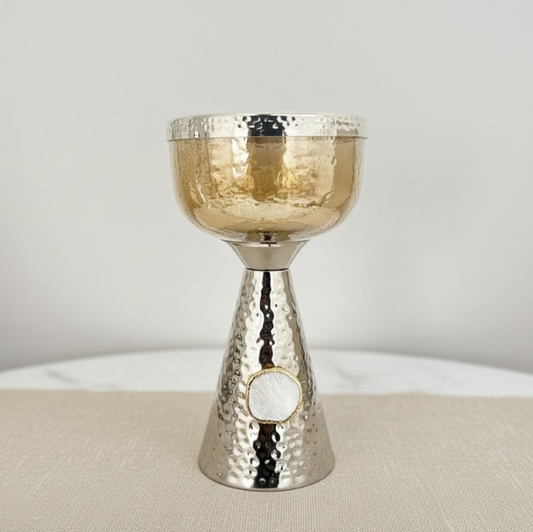 Silver and gold decorative candle holder on a neutral background