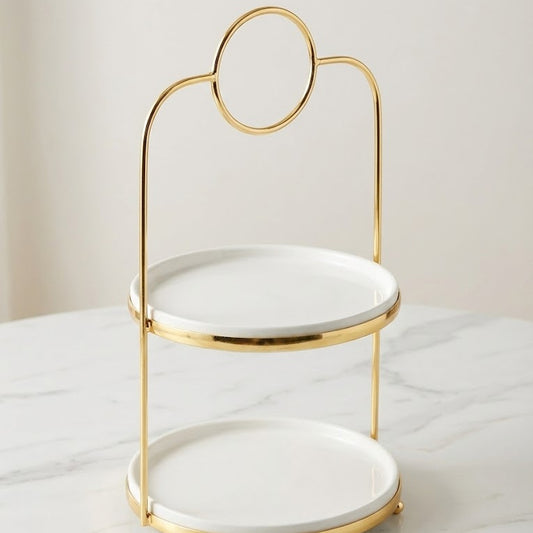 Two-tiered white dish with gold rim on a marble surface